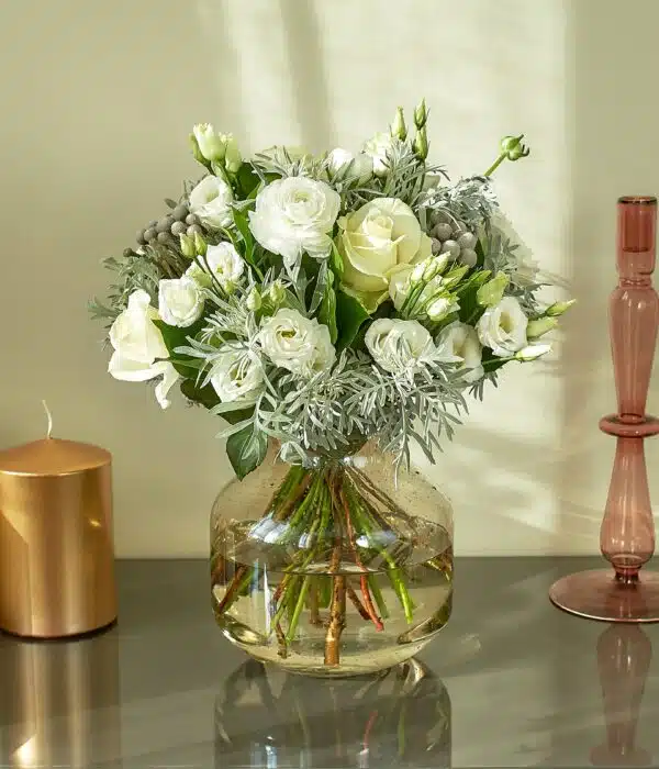 bouquet de fleurs blanches, lisianthus blancs, roses blanches, renoncules blanches, une botte de brunia gris et cinéraire gris
